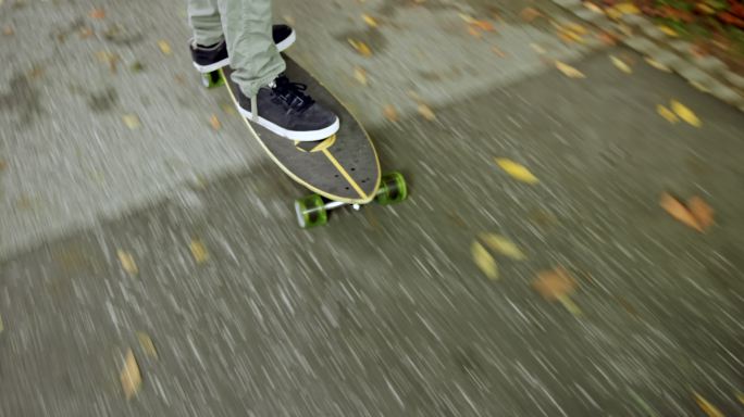 年轻人在公园里滑滑板听音乐