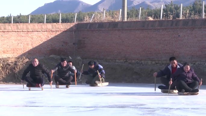 农村农民在院内冰场滑冰车玩冰车冰上运动