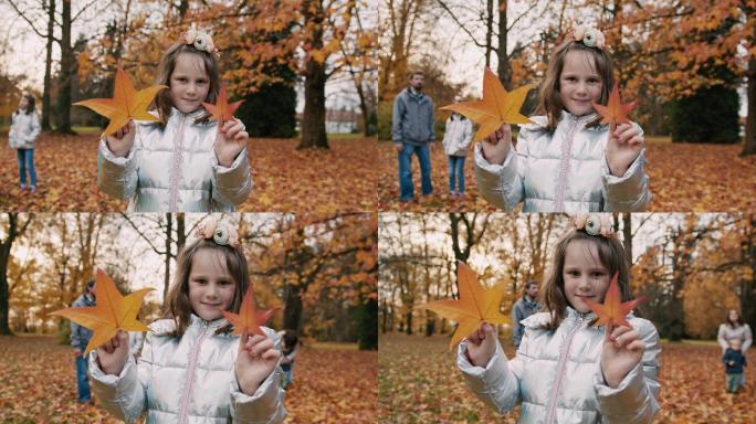 公园里拿着落叶的女孩