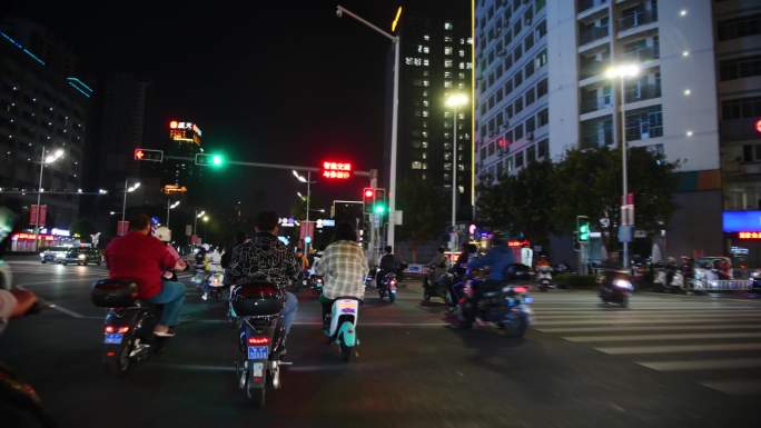 深夜城市街道醉酒骑行电动自行车过马路