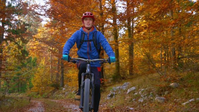 在秋天的森林里骑自行车的人