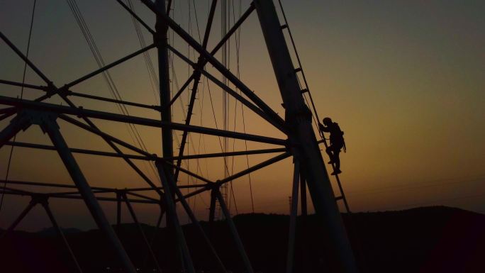 日落特高压电线安装工人爬下铁塔