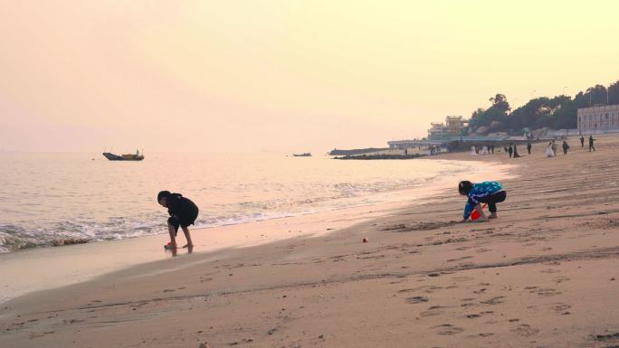 夕阳下海滩玩耍的孩子们
