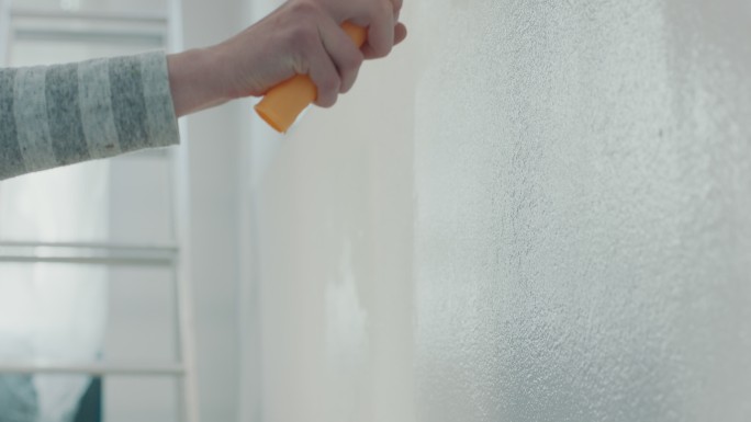 用油漆辊粉刷墙壁男人刷墙建筑工人房间翻新