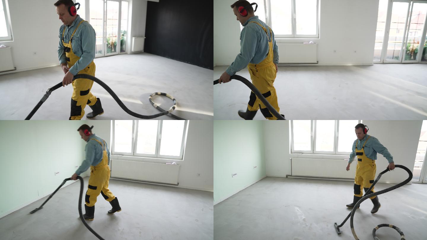 男工人用吸尘器清洁地板。