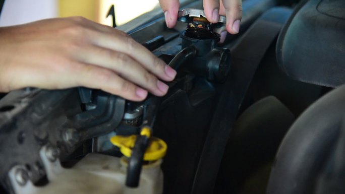 汽车修理工检查汽车的散热器。