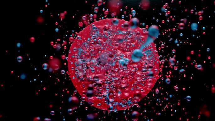 水滴从一个红色和蓝色斑点飞到空中