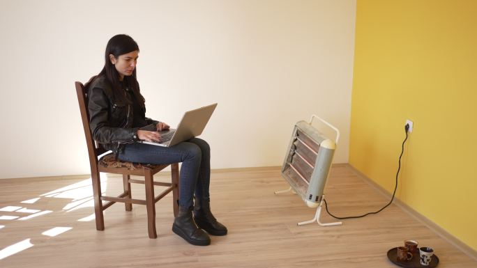 一名女子在空荡荡的公寓里使用笔记本电脑