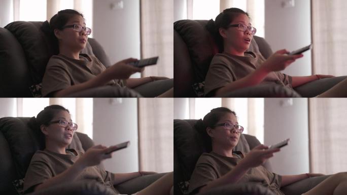 女人在家里客厅的沙发上看电视