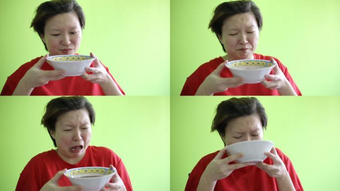 一位女性尝了一口苦味草药后的面部表情。