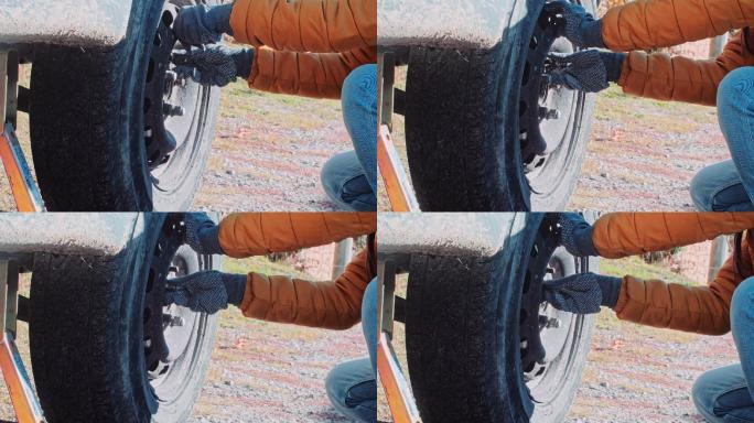 一名女子在乡村道路上更换汽车轮胎
