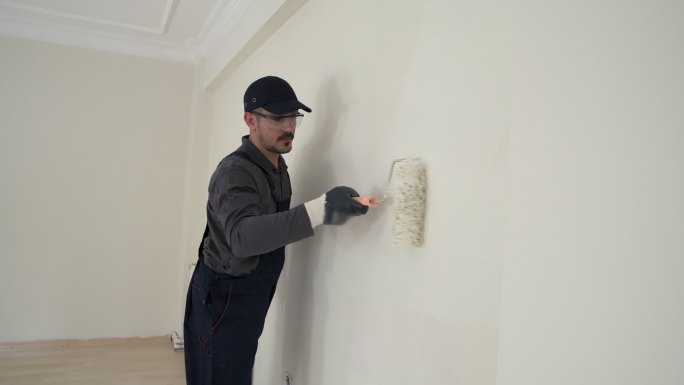 房屋油漆工在房间内刷墙