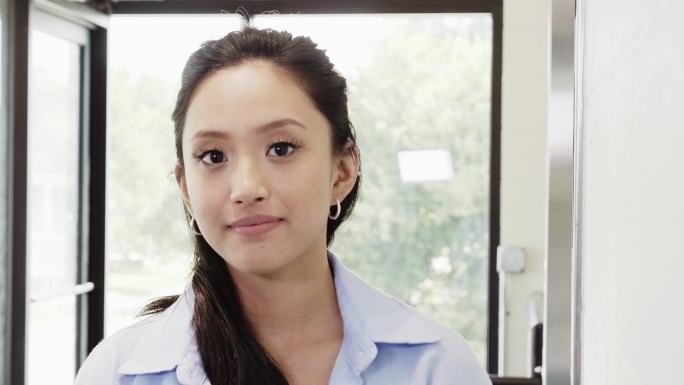 一位年轻女子表情严肃地看着摄像机