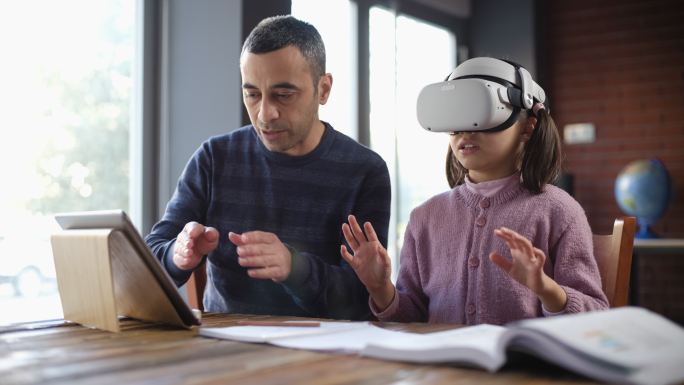 父亲和女儿在家使用虚拟现实眼镜一起学习
