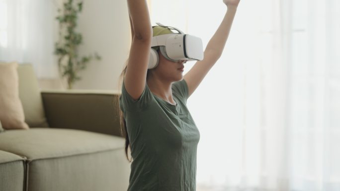 戴着虚拟现实眼镜的女人在家里锻炼