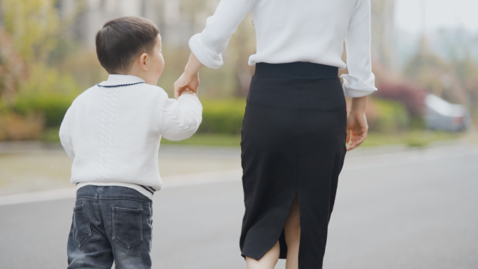 妈妈陪伴小孩散步大手牵小手送小孩上学母爱