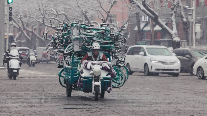 北京风雪中运输共享单车的运维人员
