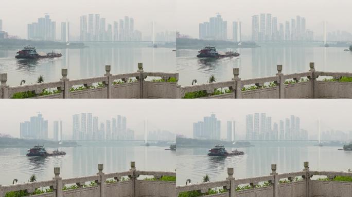 邕江上行驶的运沙船和远处青山大桥高楼大厦