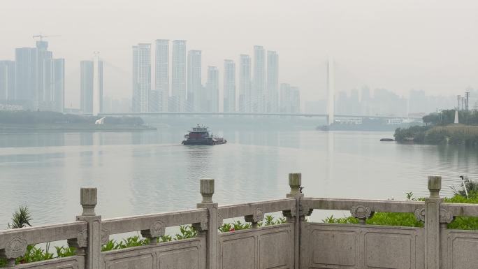 邕江上行驶的运沙船和远处青山大桥高楼大厦