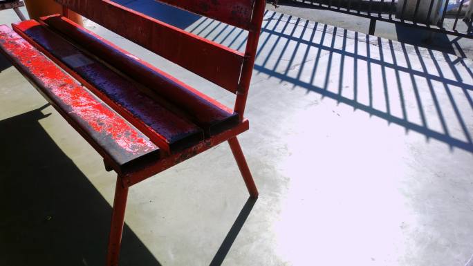 阳光下的旧红色长椅慢镜头