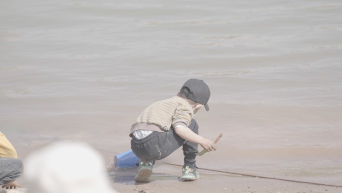 黄河边小孩玩沙子活泼可爱