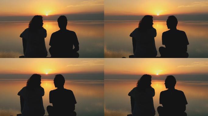 这对年轻夫妇凝视着约旦死海上方美丽的日落