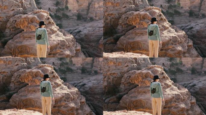 一名年轻女子站在峡谷和古老的断崖边
