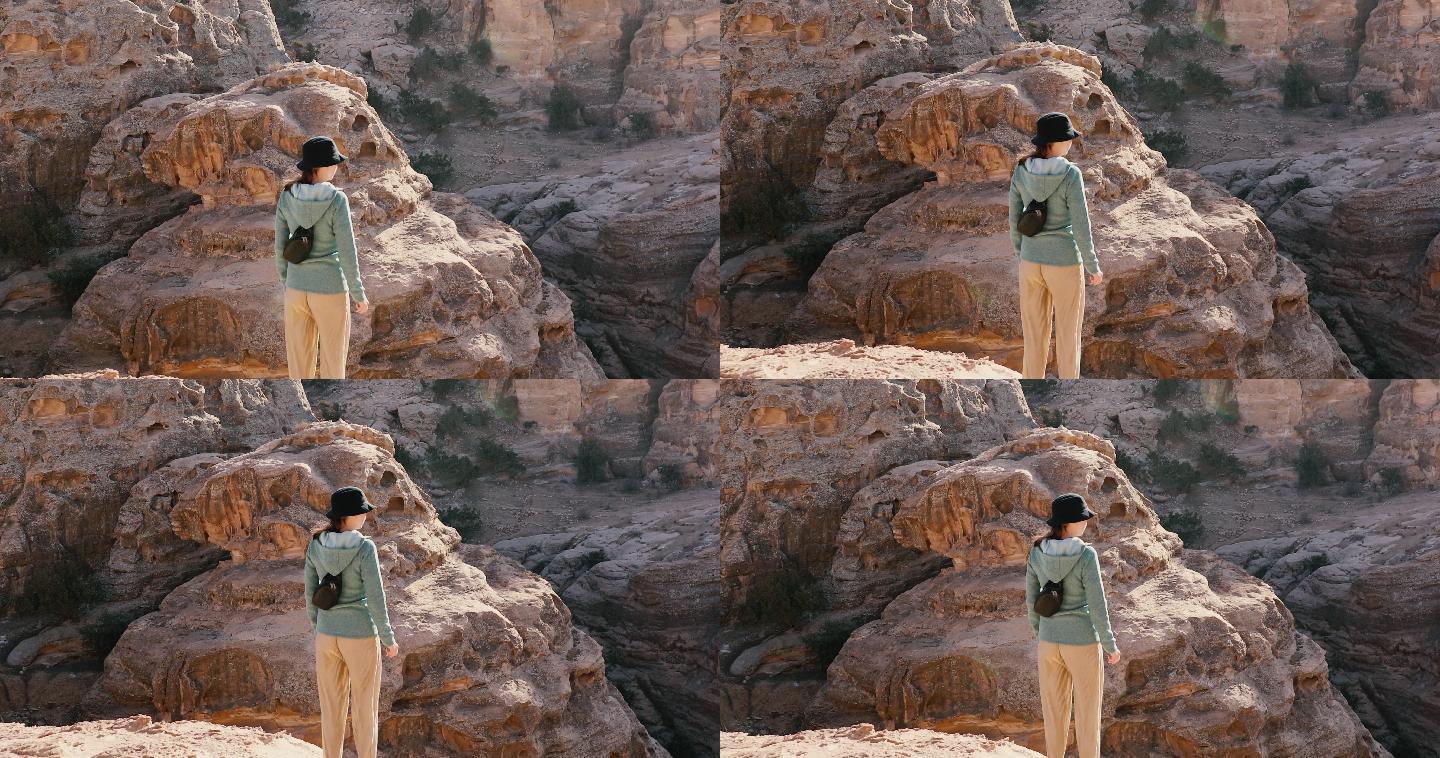 一名年轻女子站在峡谷和古老的断崖边