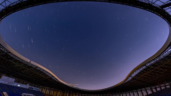 夜晚城市鸟巢形体育馆内部星轨延时摄影