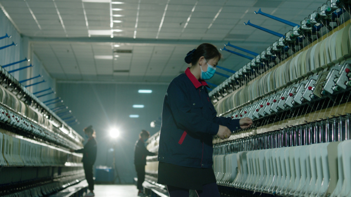 纺织工厂纺织工人在纺织车间工作