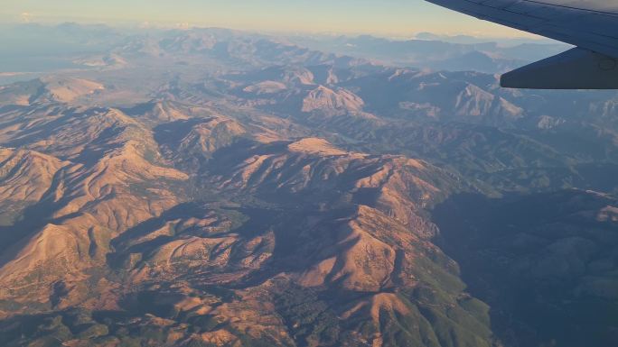 在飞越陡峭的山脉时，通过飞机窗口观看