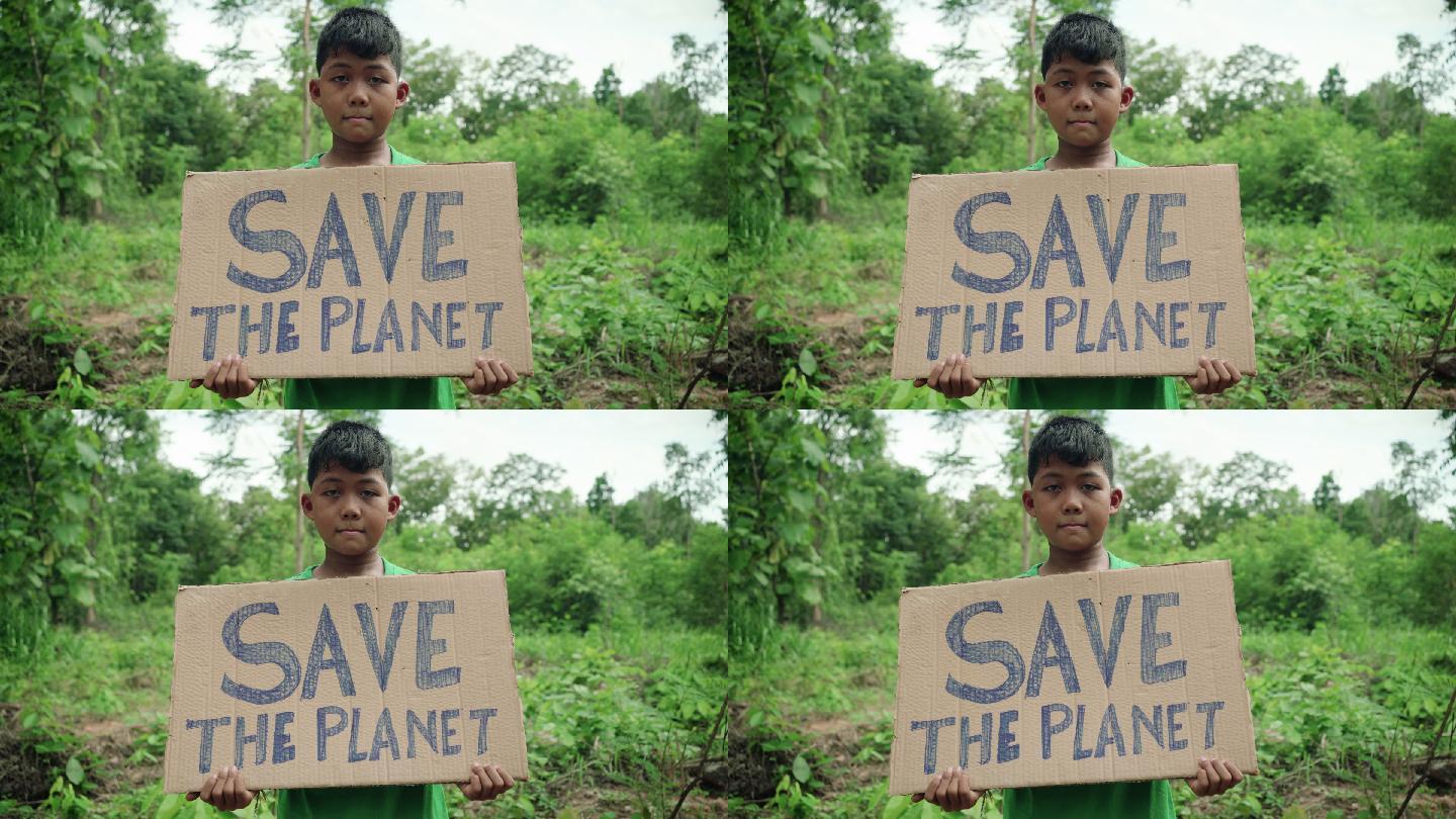 孩子手里拿着一块写着“拯救地球”的牌子