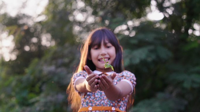 可爱的小女孩拿着小植物