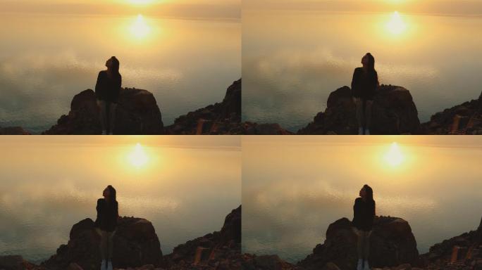 一名女子凝视着风景如画的日落