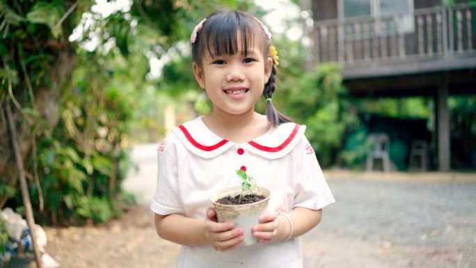 女孩拿着一个小花盆