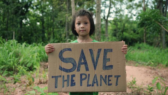 孩子拿着一块写着“拯救地球”的牌子