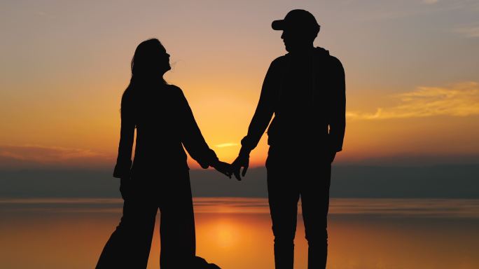 年轻夫妇站在海边的背影