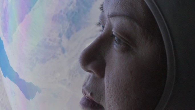 女宇航员从太空飞船的窗口看地球
