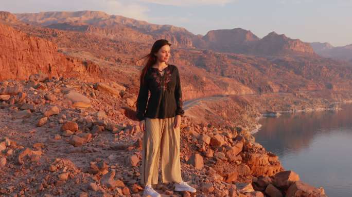 女性旅行者凝视着约旦死海上方美丽的日落