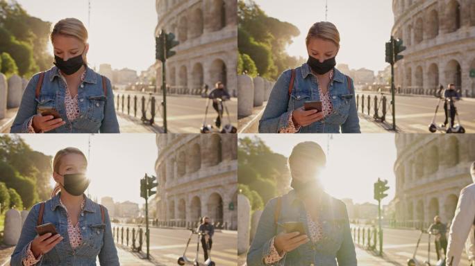 女游客在著名的斗兽场散步时使用智能手机