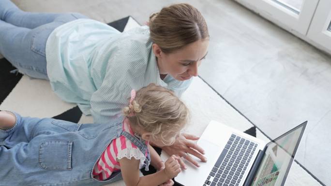 母亲和女儿一起使用笔记本电脑