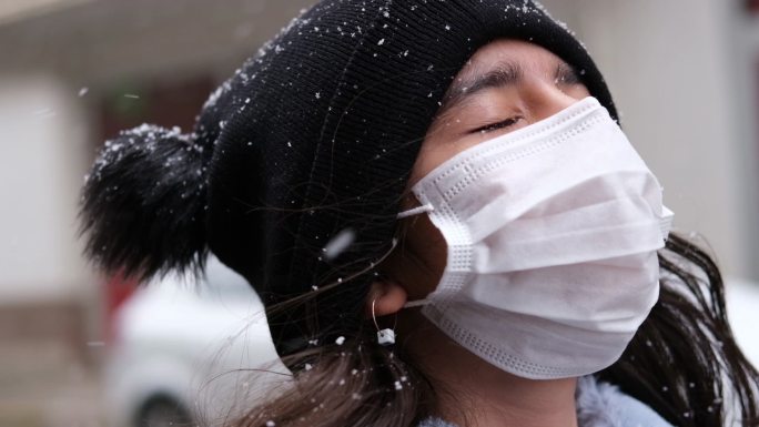 戴着口罩的女孩冬季雪花下雪雾凇风景