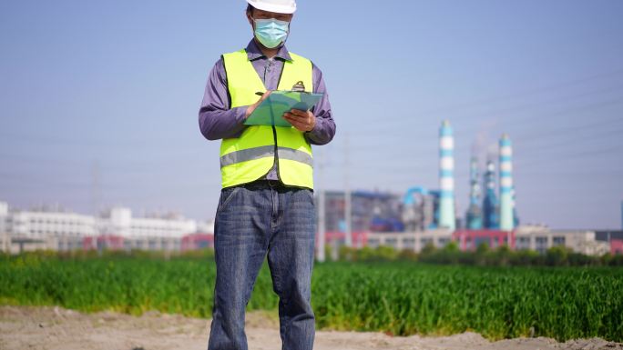 年轻工程技术人员拿着文件夹项目现场记录