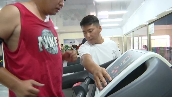 市民在健身馆健身房跑步机上锻炼蹬自行车