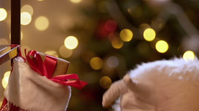 一个圣诞故事，圣诞老人的手用手指啪的一声，圣诞袜子里出现了一份礼物。