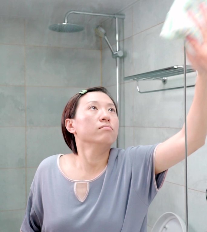 在家打扫卫生擦镜子的东方女性