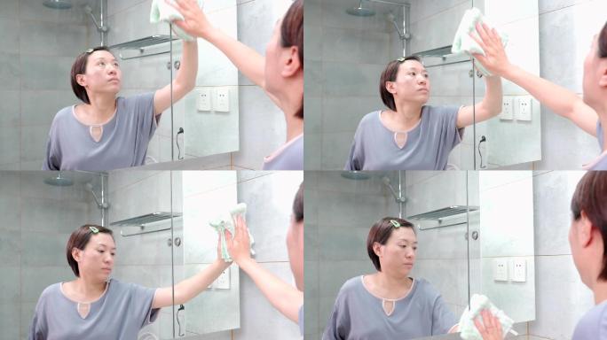 在家打扫卫生擦镜子的东方女性