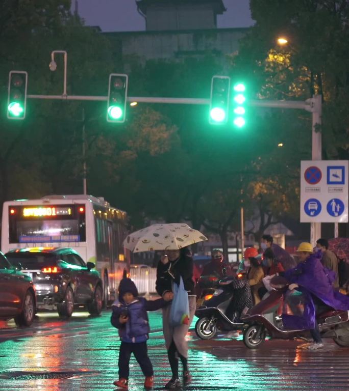 风雨天夜晚路口形形色色的行人