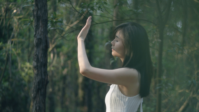 清新唯美女孩在树林里伸手遮挡太阳4k素材