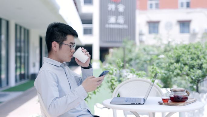4K青年男性户外喝咖啡办公看手机